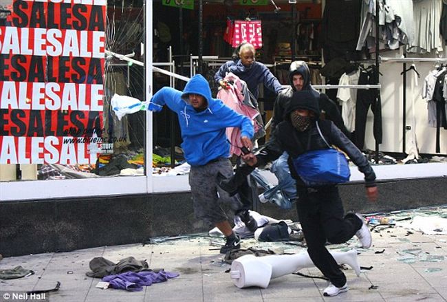 the runLooters burst through the window shop Peckham high street carrying their spoils 